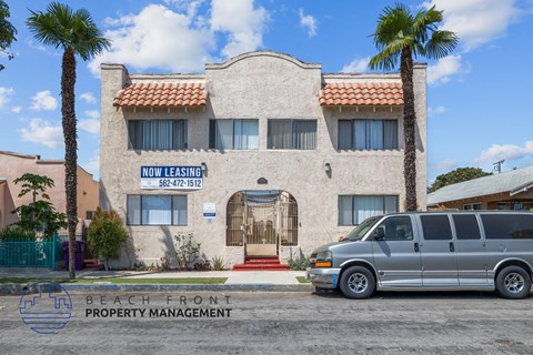 a van parked in front of a building with palm trees