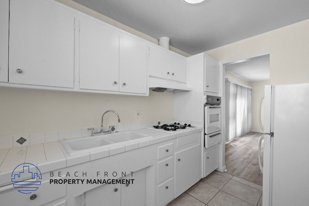 a white kitchen with white cabinets and a white sink