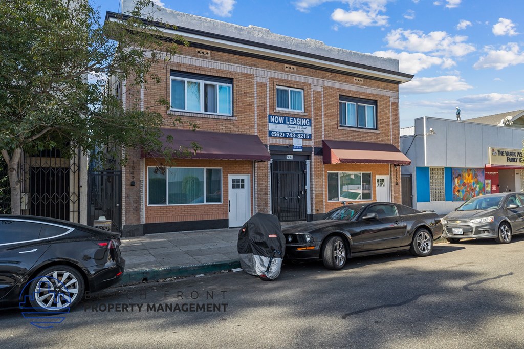 a parking lot with cars parked in front of a brick building