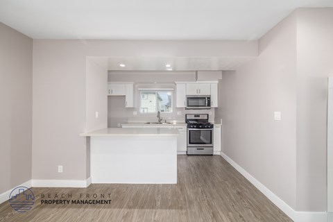 A kitchen with a white island and wooden floors.