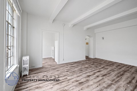 a living room with white walls and a wood floor