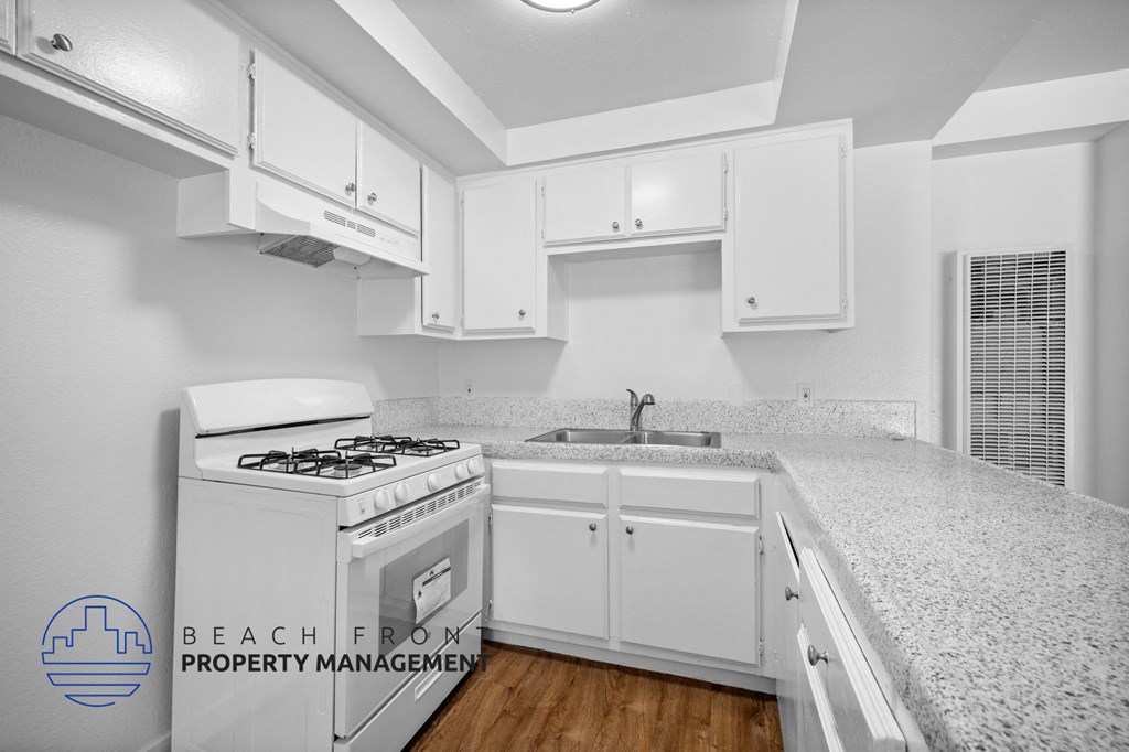an image of a kitchen with white cabinets and a white stove and white counter tops
