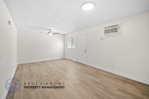 the living room of a house with a hardwood floor and white walls