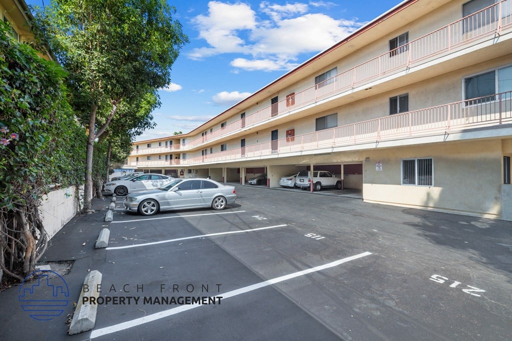 A parking lot with cars and a building in the background.