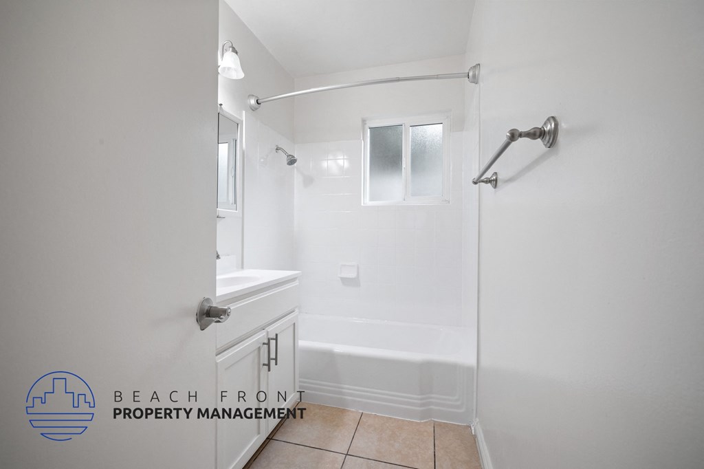 a white bathroom with a tub and a sink and a shower