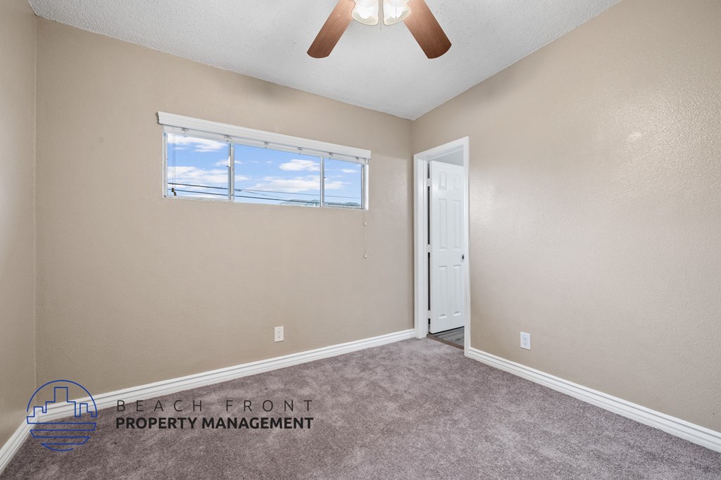 the living room of a house with a ceiling fan and a window