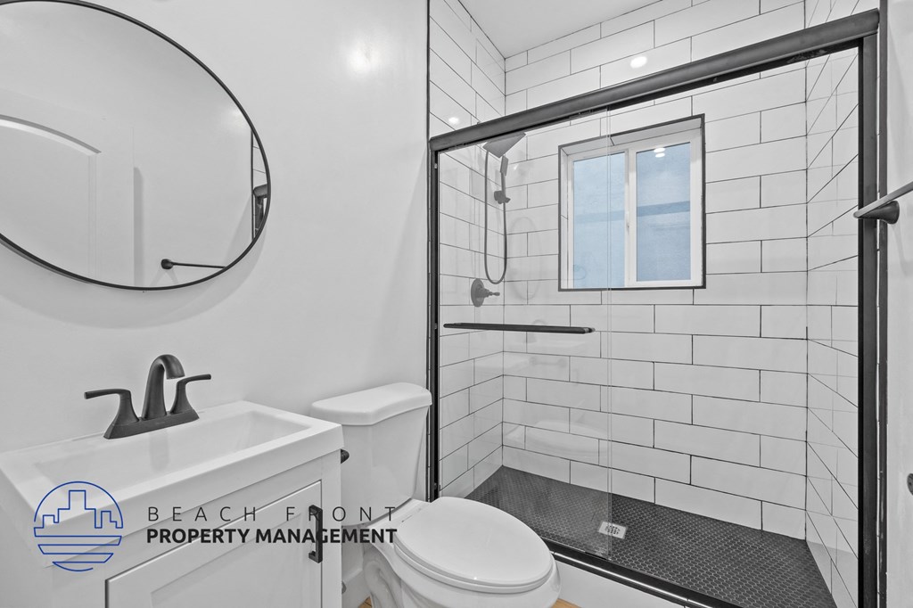 a bathroom with a toilet sink and shower and a mirror