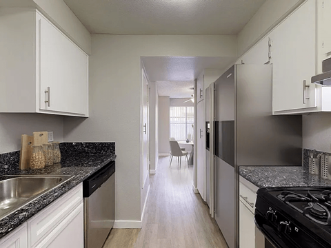 A kitchen with white cabinets and a black stove top oven.