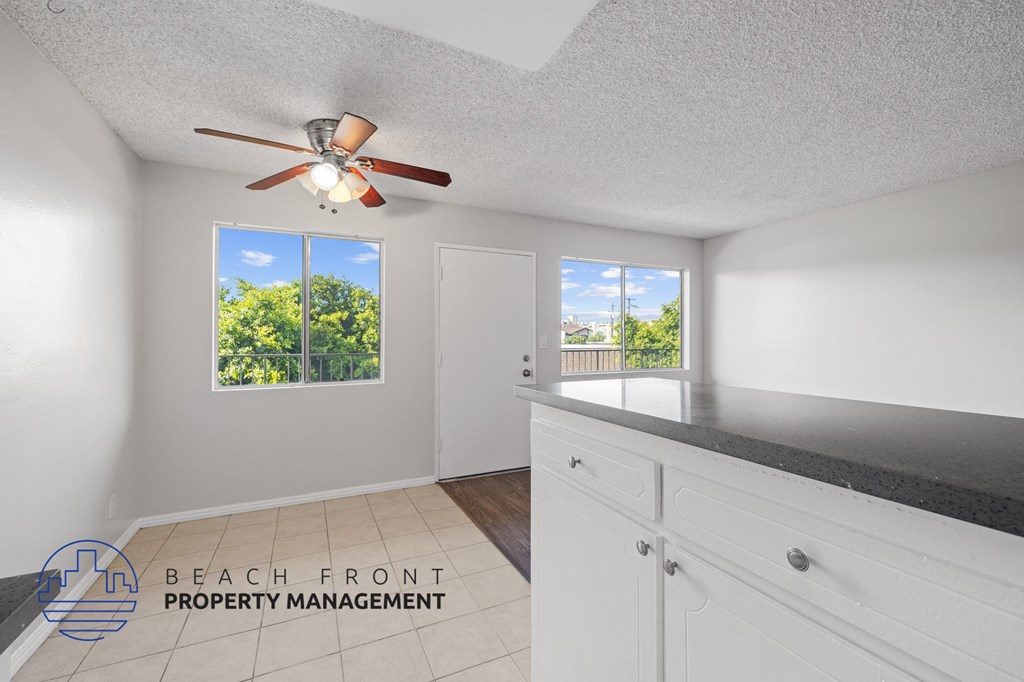 a kitchen with a counter top and a ceiling fan