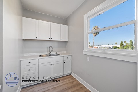 a kitchen with white cabinets and a sink and a window