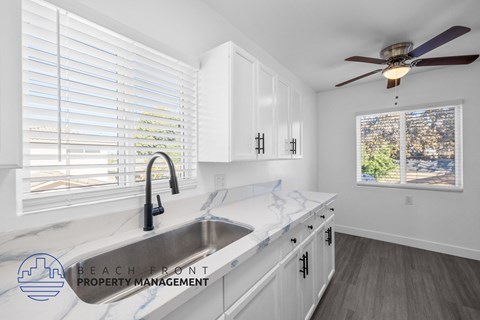 A kitchen with a marble countertop and a view of the city through the window.