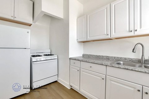 A kitchen with white appliances and cabinets.