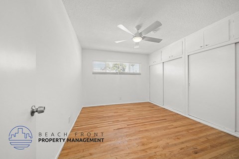 a bedroom with white closets and a ceiling fan