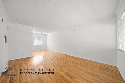 the living room and dining room with wood floors and white walls