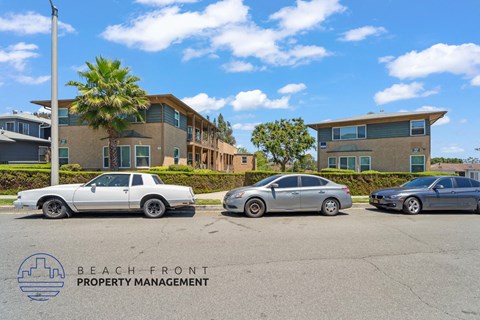 Two cars parked in front of a building with the logo "BEACH FRONT PROPERTY MANAGEMENT" on the bottom left.