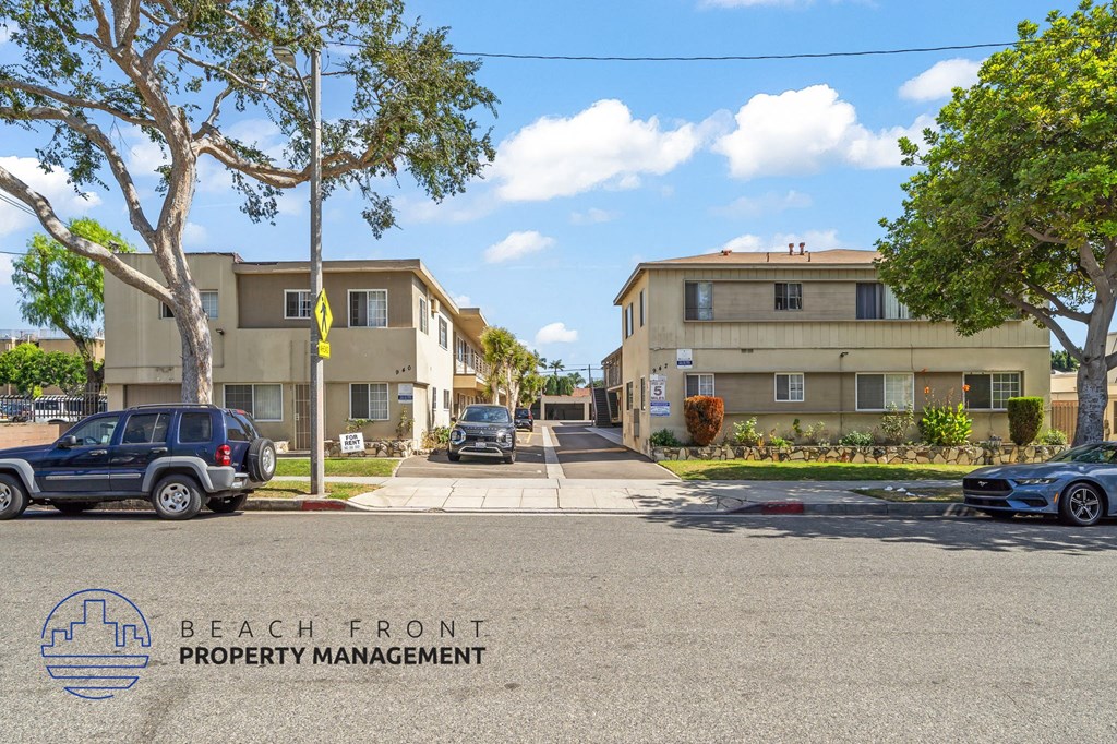 A street view of a residential area with the logo of Beach Front Property Management visible on the ground.