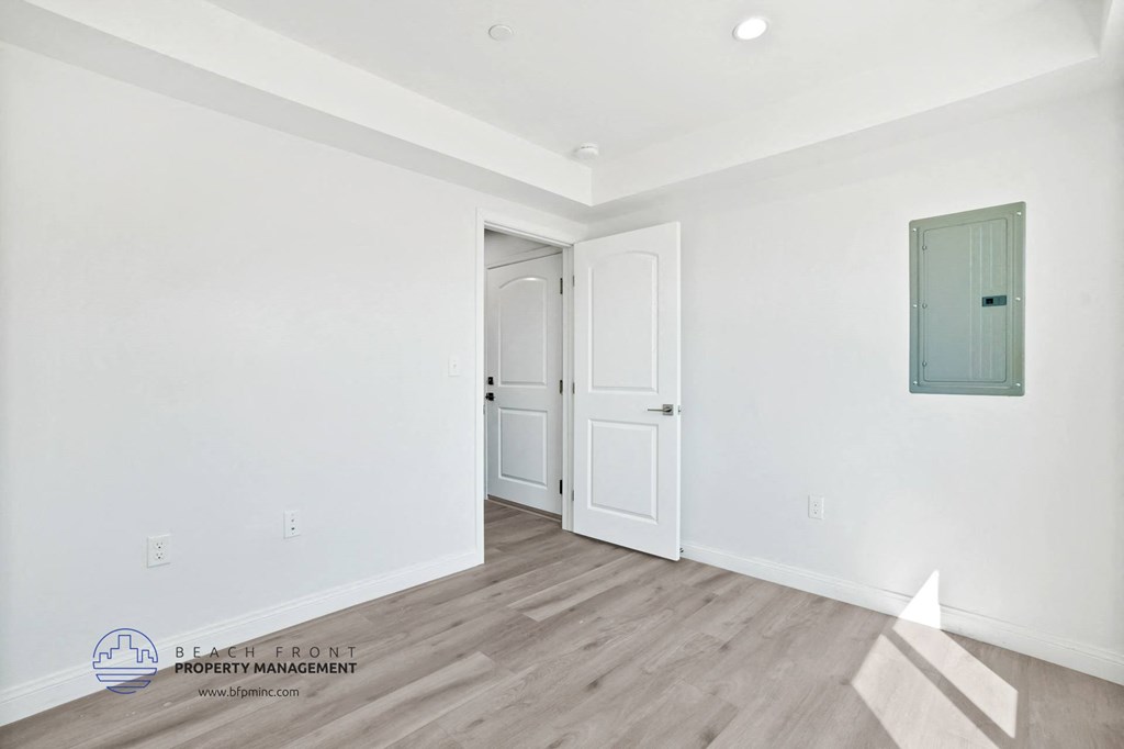 a white room with two doors and a white wall and a wooden floor
