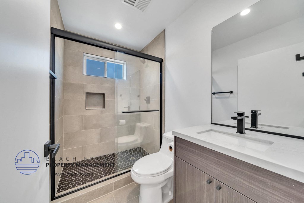 a bathroom with a shower and a toilet and a sink