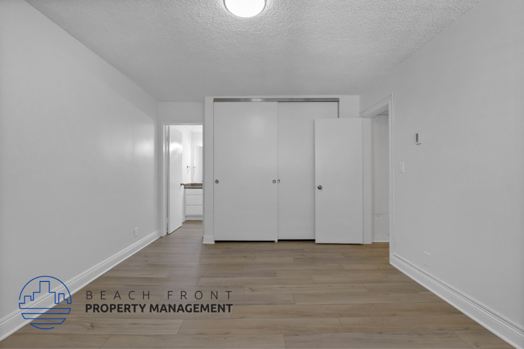 a renovated living room with white walls and wood flooring