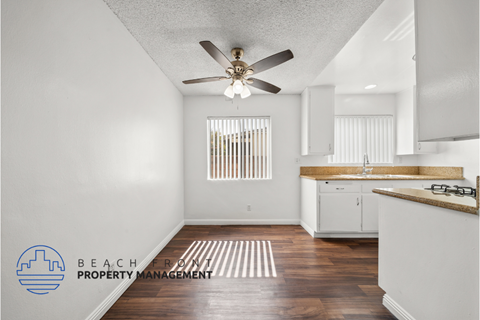 a kitchen with white cabinets and a ceiling fan