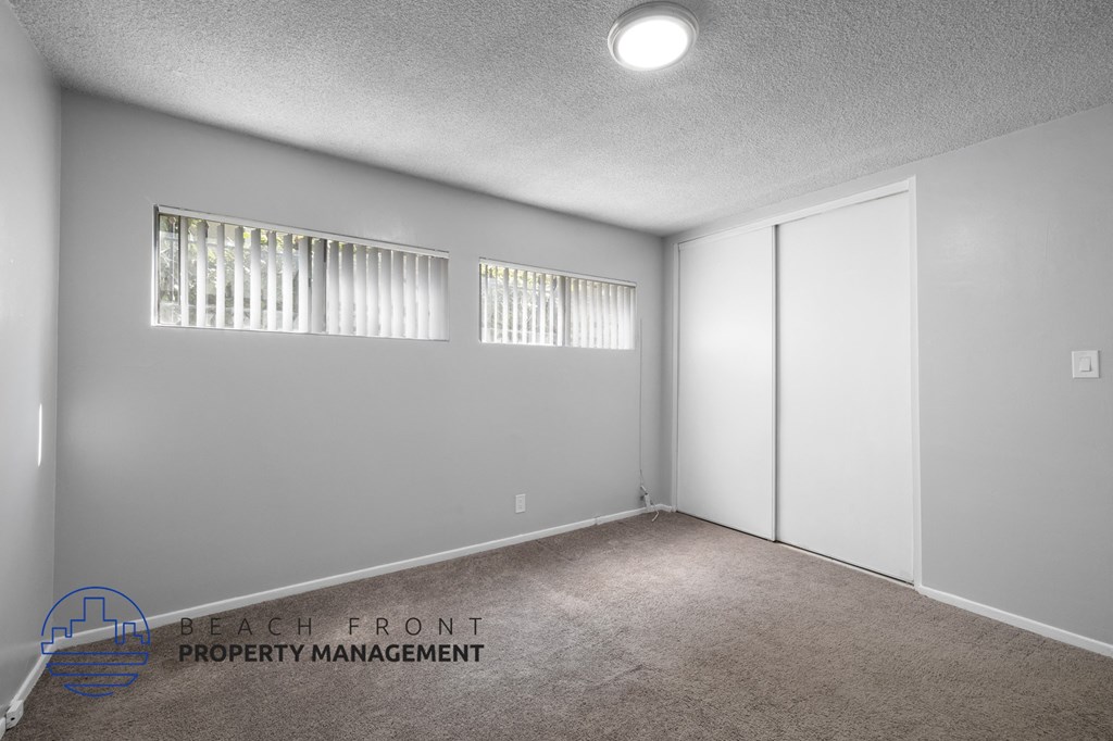 the living room of a house with white walls and carpet