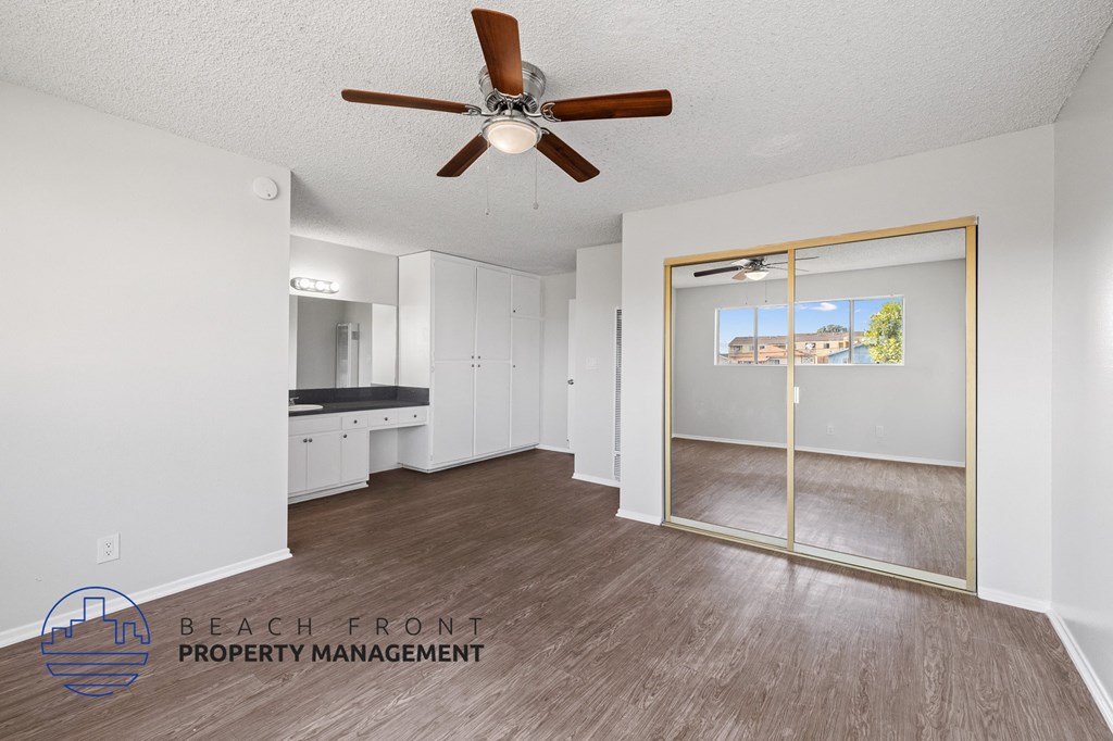 a living room with a ceiling fan and a mirror