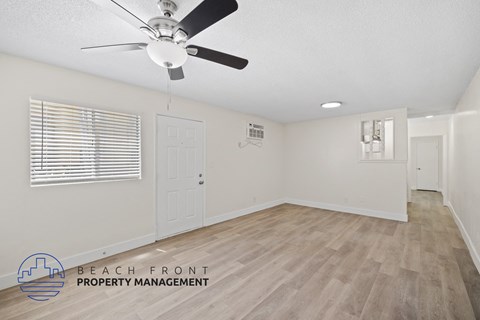 a living room with a ceiling fan and a door