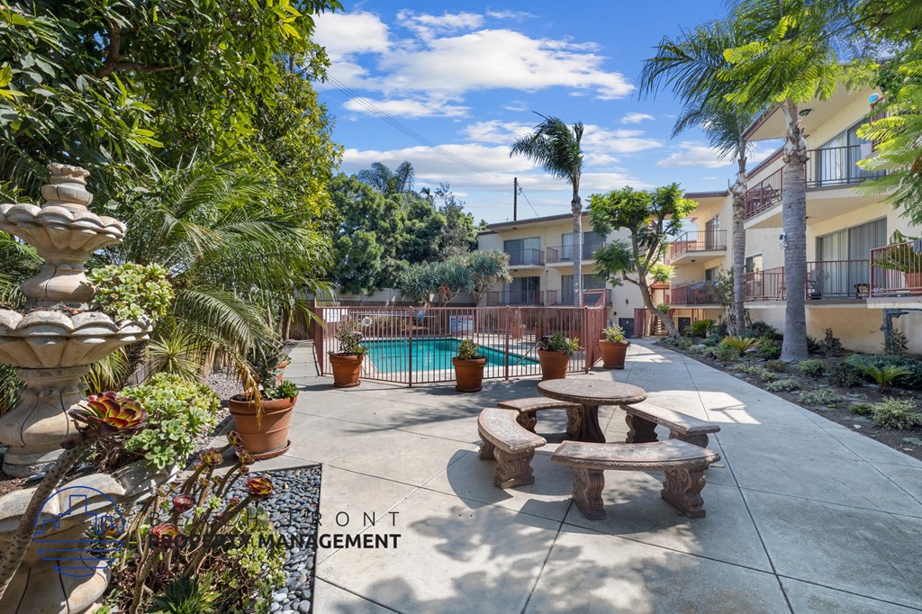 A patio area with a pool and a fountain.