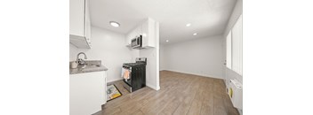 A kitchen with a black fridge and a microwave above it.