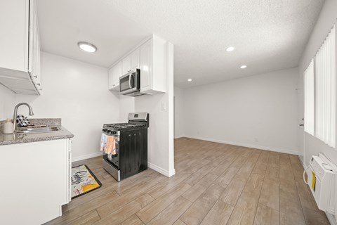 A kitchen with a black fridge and a microwave above it.