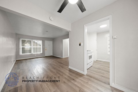 A spacious room with a fan and a window with bars.