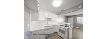 A modern kitchen with a stove top oven and white cabinets.