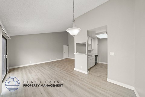 the spacious living room and kitchen of this renovated beachfront property