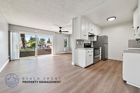 A kitchen with a refrigerator, oven, and microwave in a property management office.