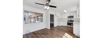 A well-lit kitchen and living area with a logo for Beach Front Property Management.