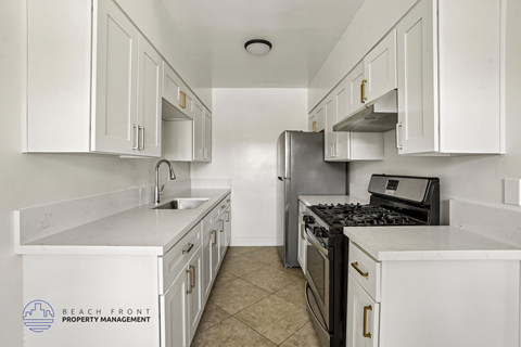A kitchen with white cabinets and a black stove top oven.