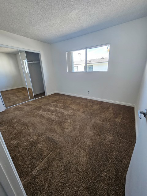 an empty room with carpet and a window