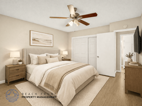 A bedroom with a large bed, a ceiling fan, and a painting on the wall.