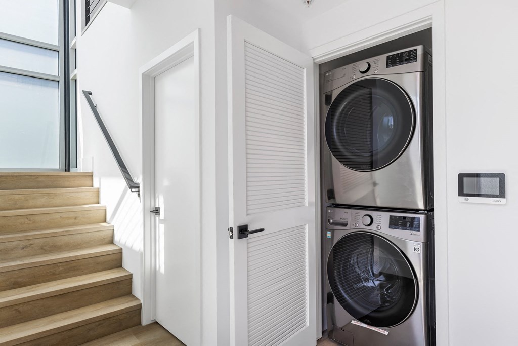 a laundry room with a washing machine and a door