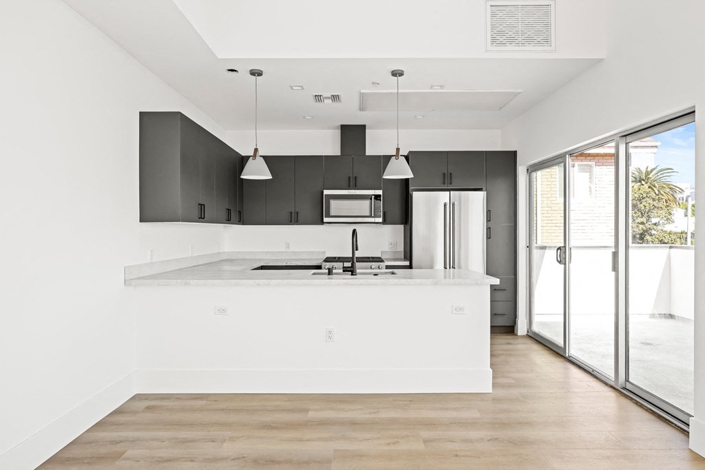 a white kitchen with a large island and black cabinets