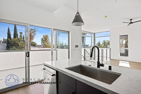 a kitchen with a large sink and a view of a balcony