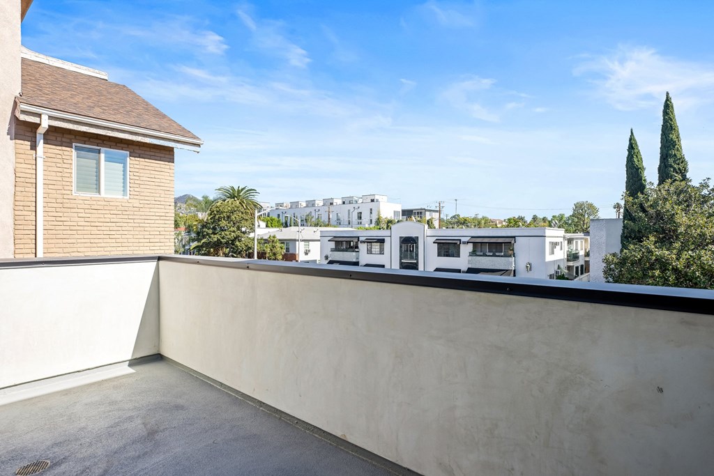 the view from the roof terrace of a house with a balcony and a building