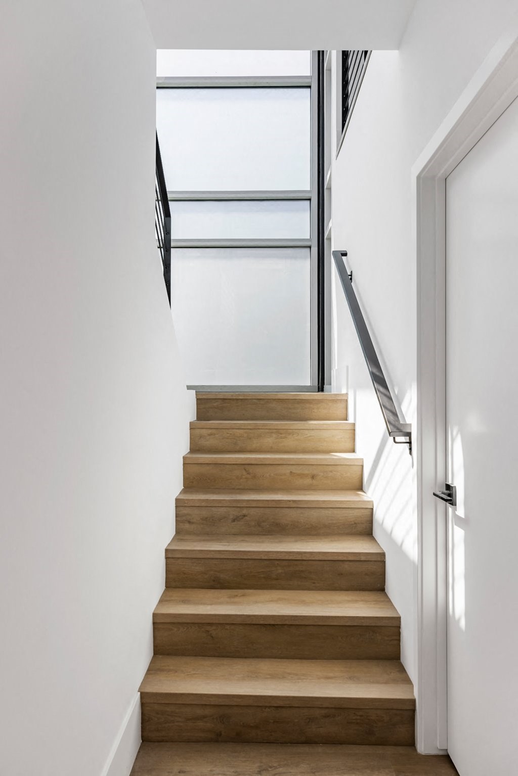 a staircase with wood treads and a glass door