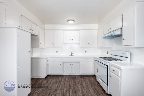 A kitchen with white cabinets and appliances.
