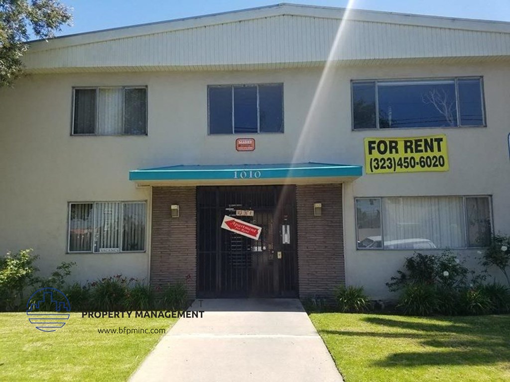 the front of a building with afor rent sign on it