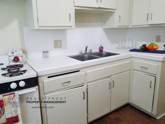 a small kitchen with white cabinets and a sink