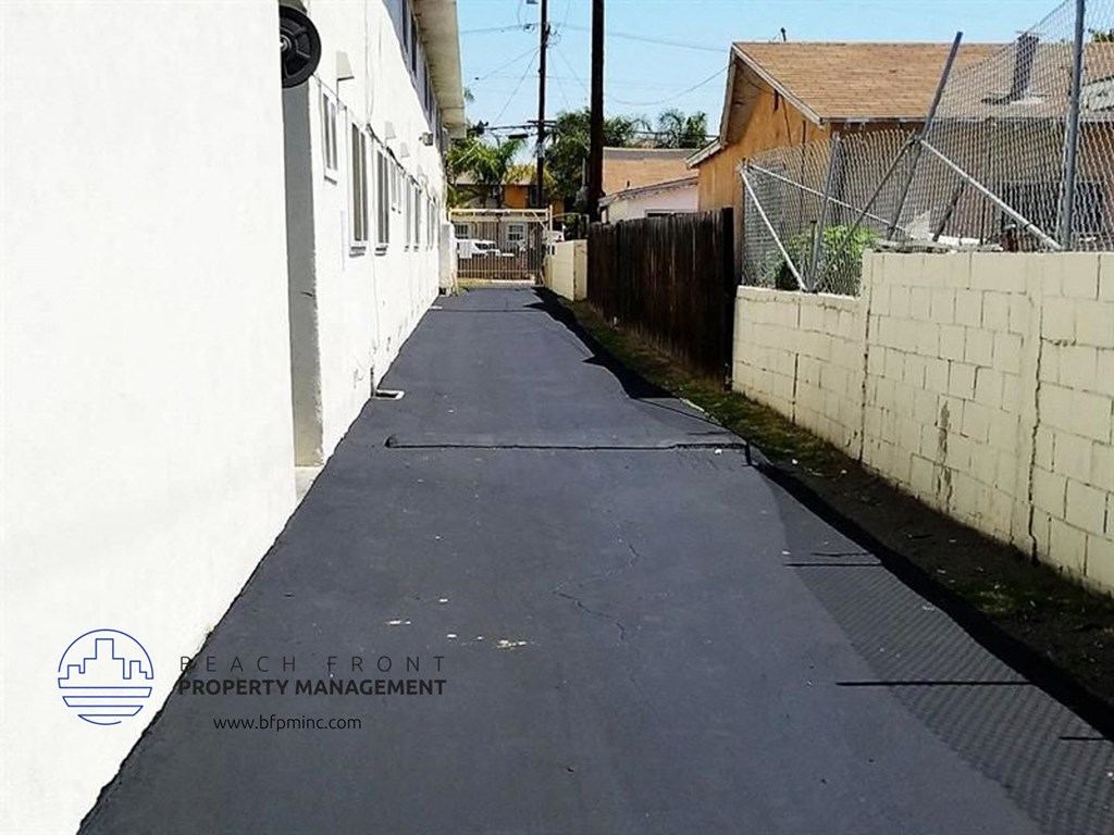 a walkway between two buildings with a fence on the side of it