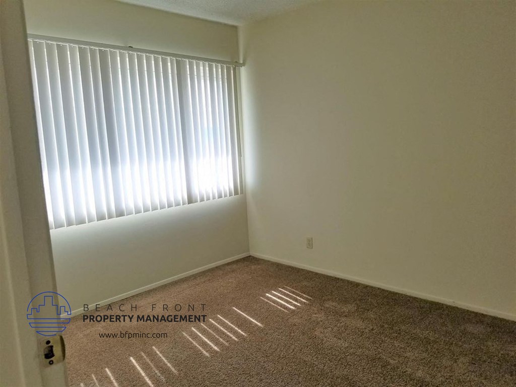 an empty room with a window and a carpet