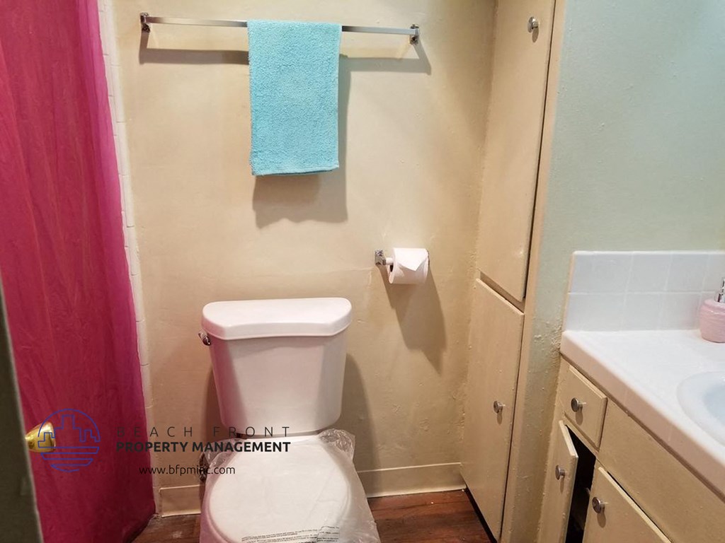 a small bathroom with a toilet and a blue towel