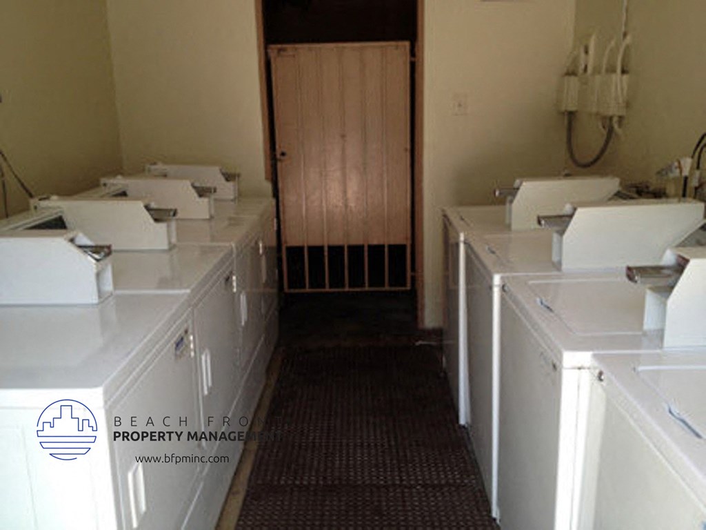 a laundry room filled with white washers and dryers